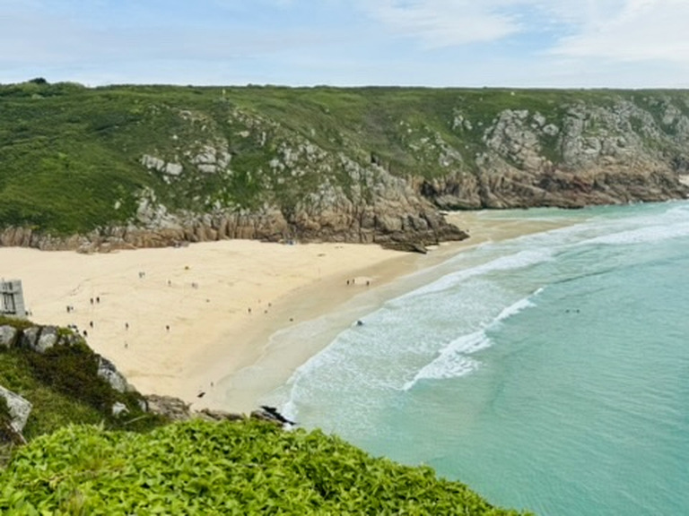 A turquoise cove below green cliffs